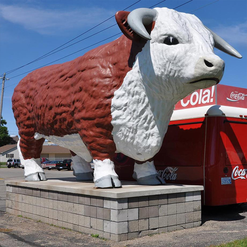 Гигантская скульптура коровы с цветком из стекловолокна